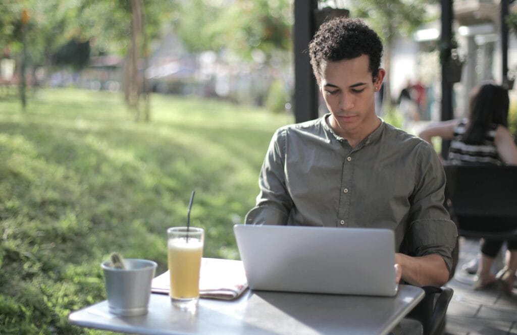 Een freelancer aan het werk met zijn zakelijke laptop in een cafe.
